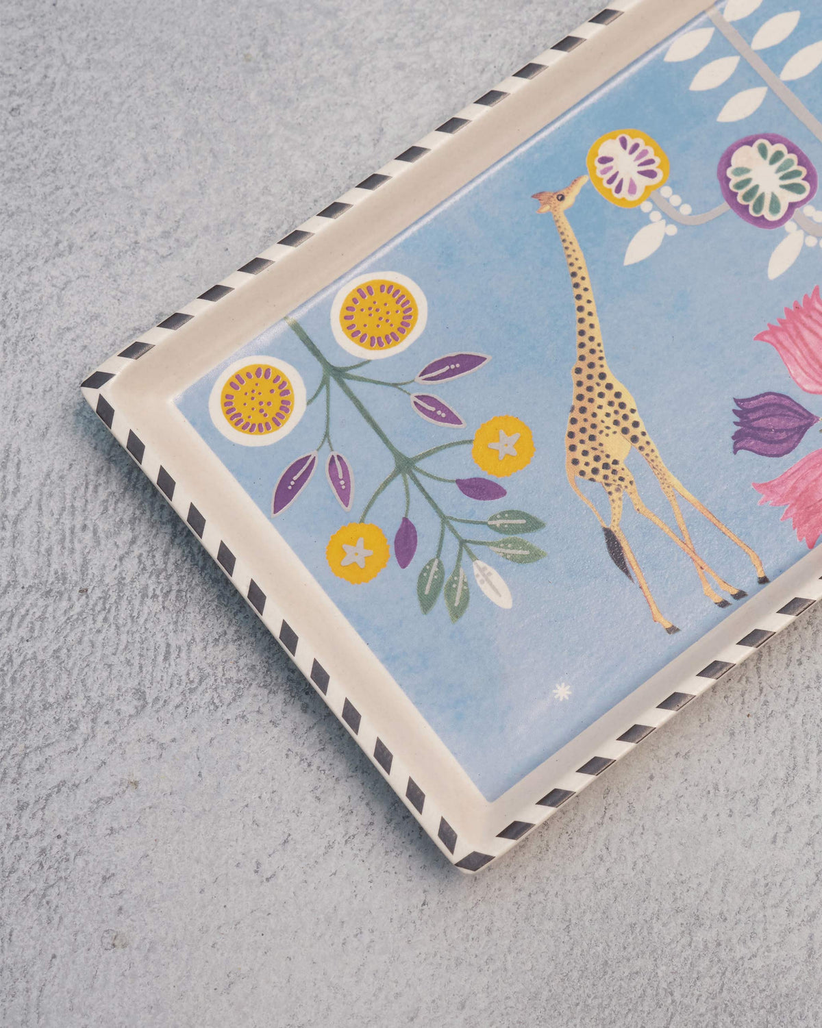 Close-up of the Bahari Cookie Tray's corner showing its giraffe and flower print.