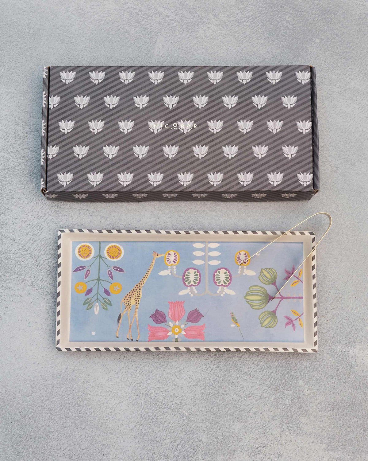 Bahari Cookie Tray with a giraffe and flower design, shown beside its gift box.