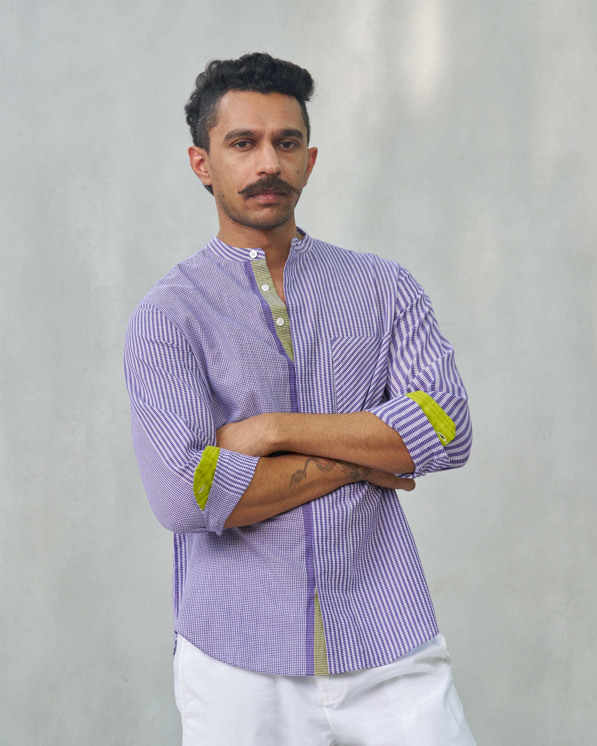 Person wearing a purple Summer Fridays Pocket Shirt with arms crossed.
