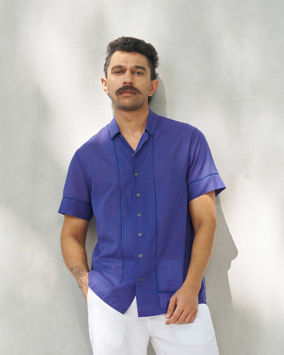 Person wearing a Coastal Shirt in purple and berry check with short sleeves.