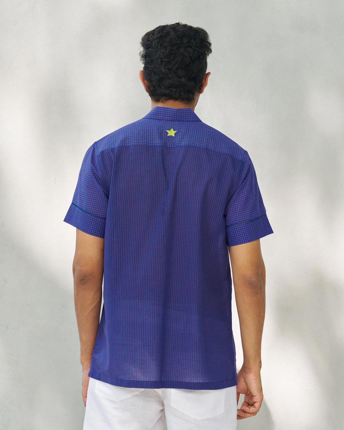 Back of a Coastal Shirt with a yellow-green star on the yoke, worn by a person.
