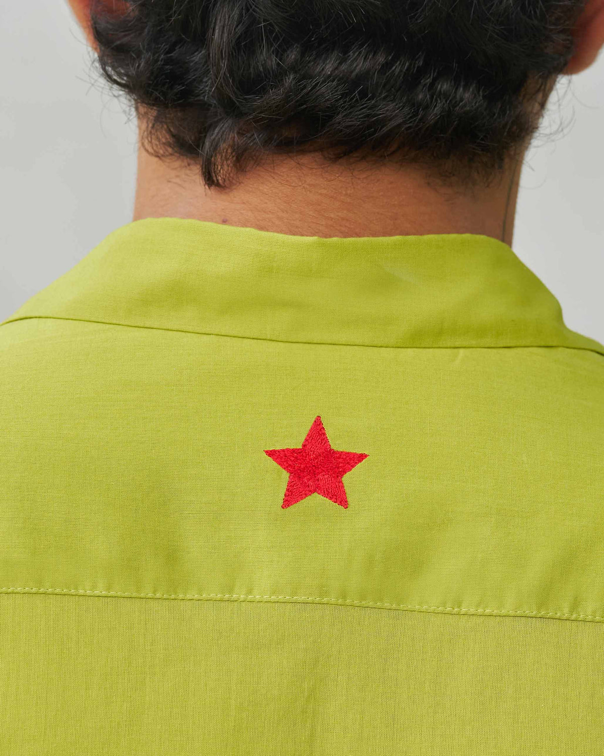 Close-up of the Padma Shirt's back yoke showing a red star embroidery.