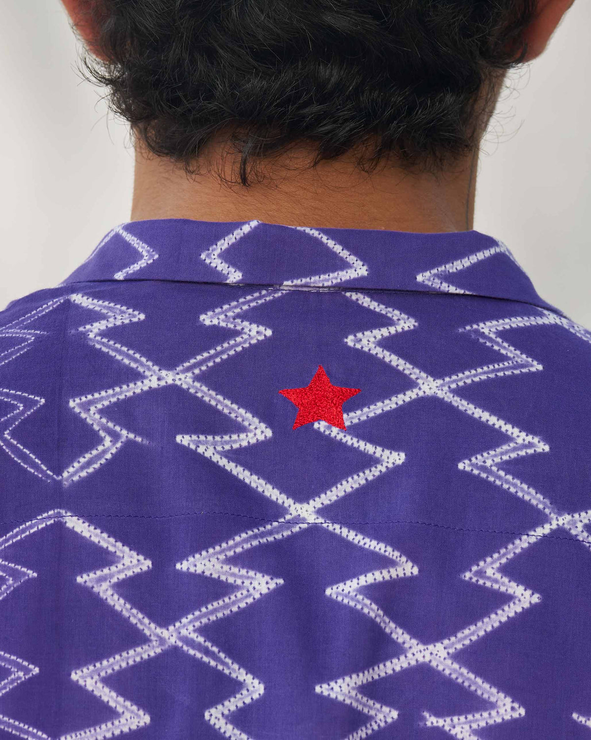 Close-up of a purple Riverine shirt back with a red star embroidered on the upper back.