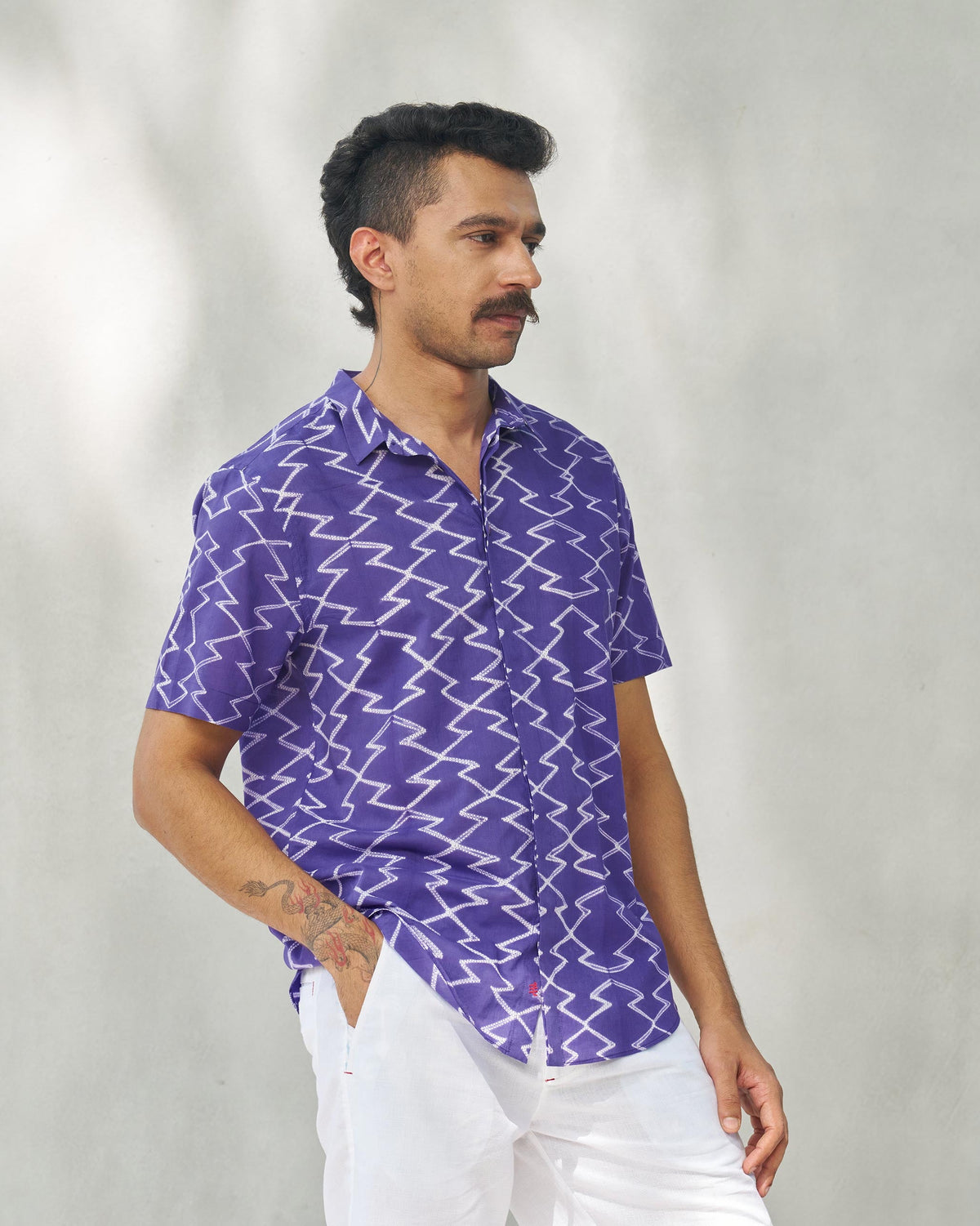Side view of a purple Riverine shirt worn by a person, with short sleeves.