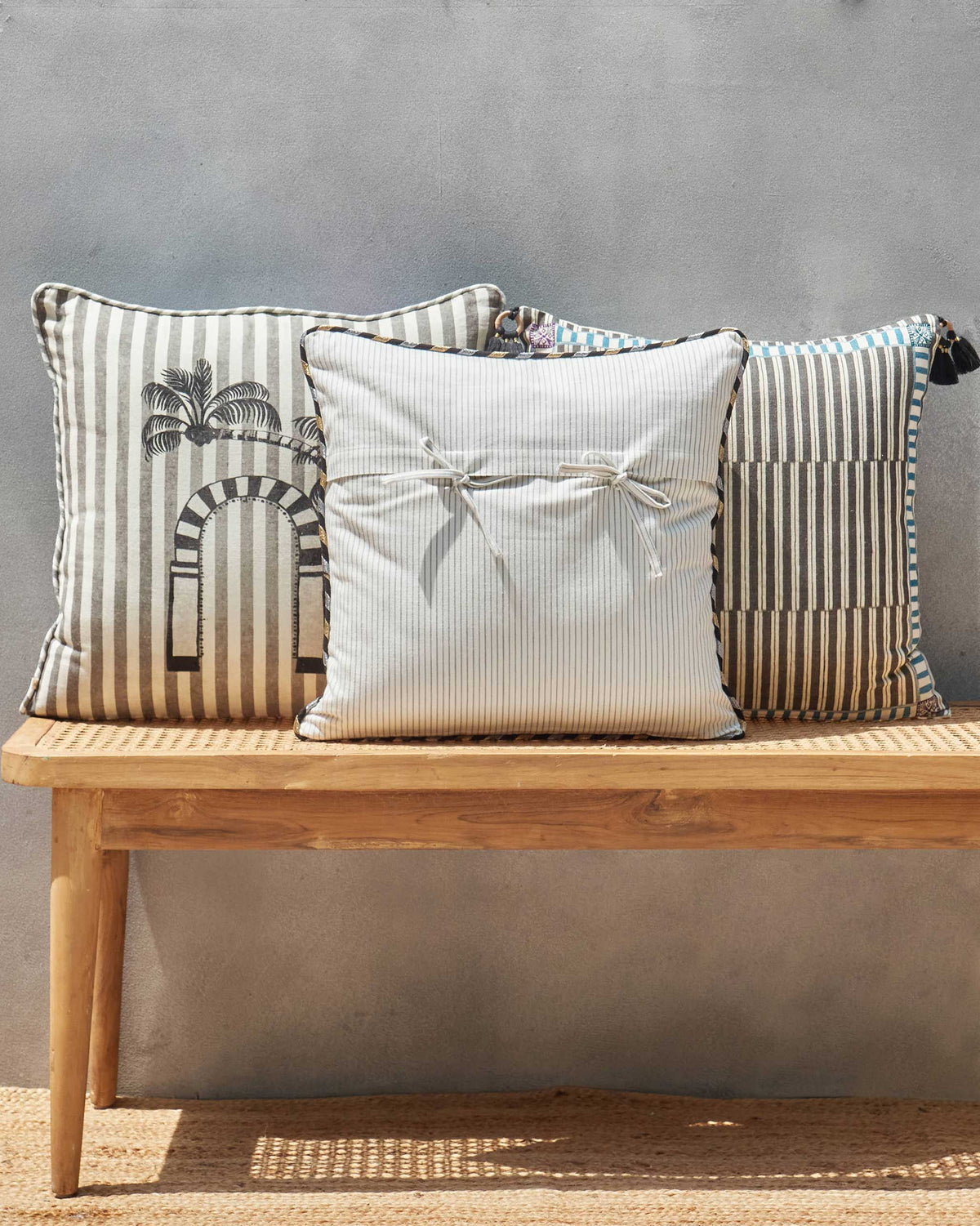 Cream striped cushion cover with bow ties at the centre.