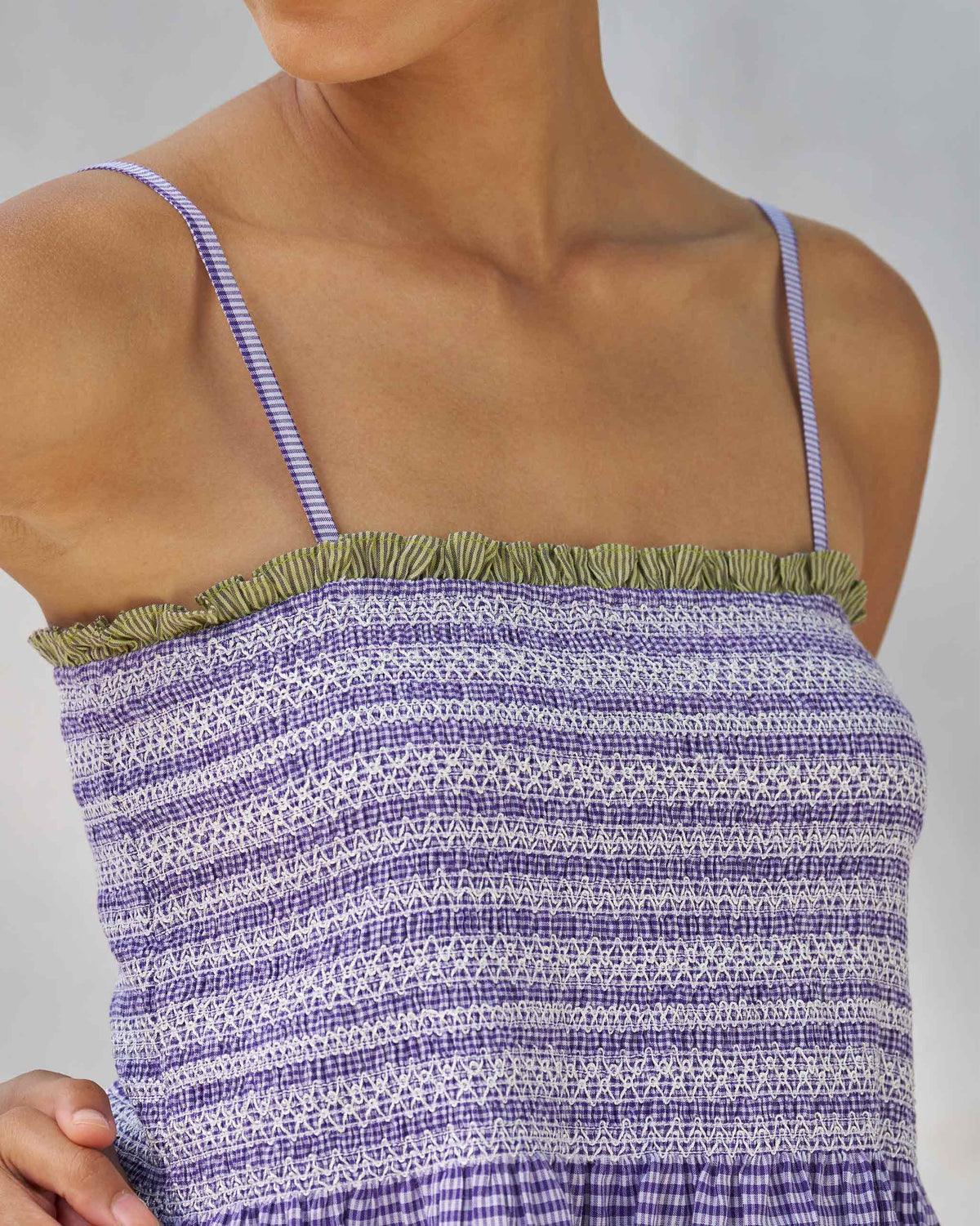 Close-up of the smocked bodice and green neck trim on a purple and white Paradise top.