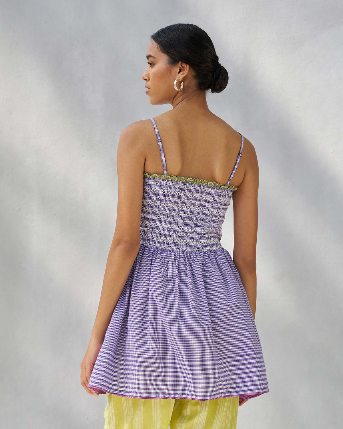 Back of a purple and white Paradise top with a smocked bodice and thin straps.