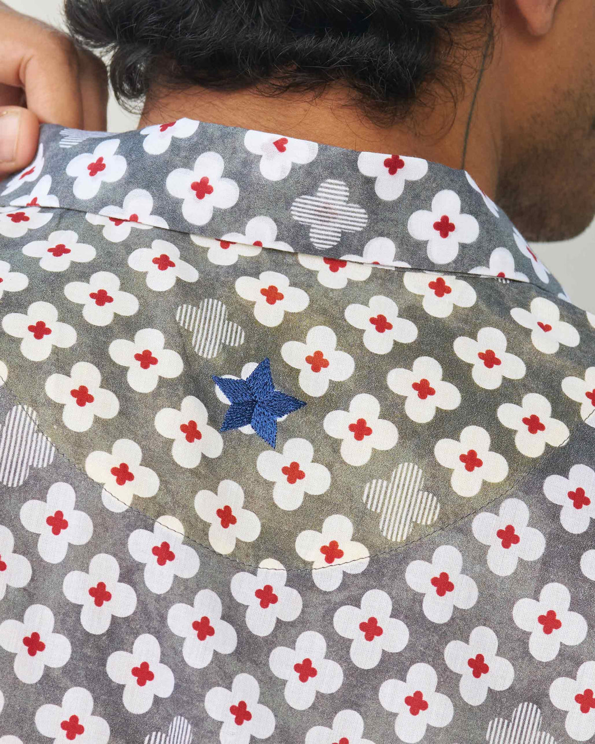 Close-up of the back collar of a grey Mistari shirt showing a blue star.