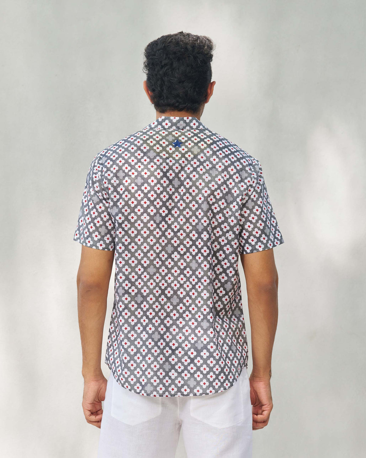 Back of a grey Mistari shirt worn by a person.