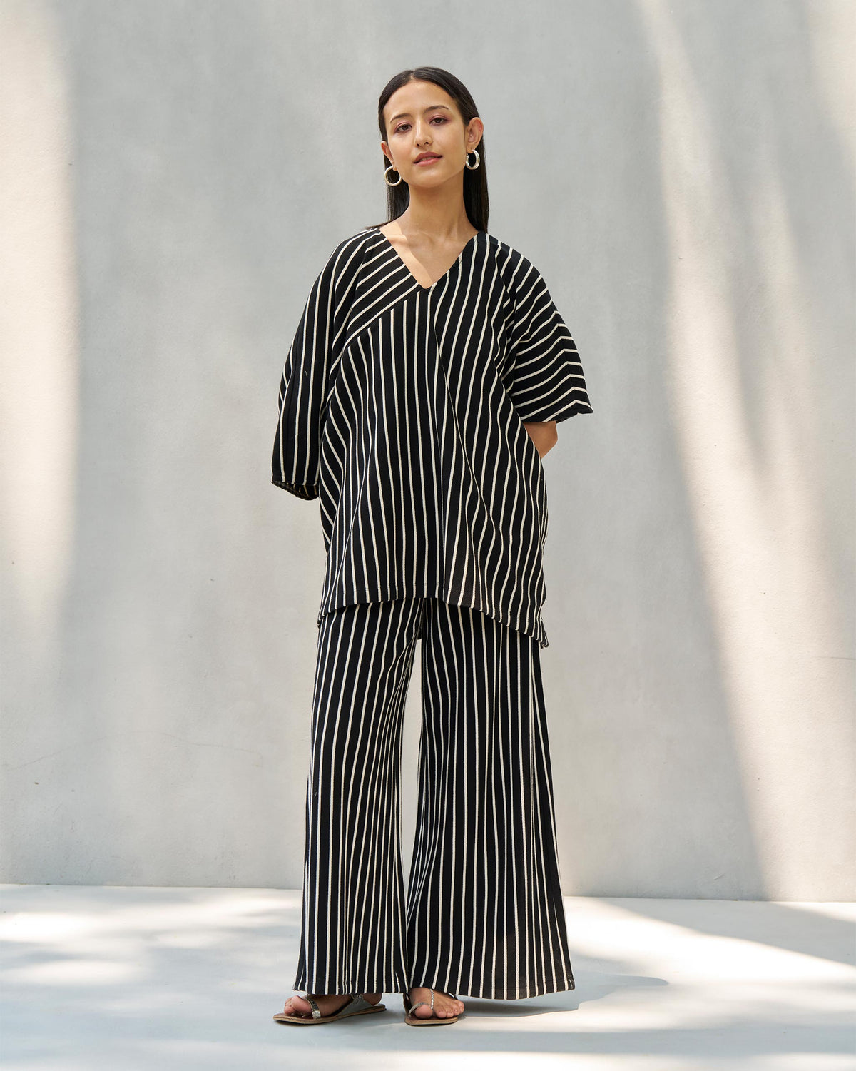 Person wearing black and beige striped Nova pants, shown full-length.