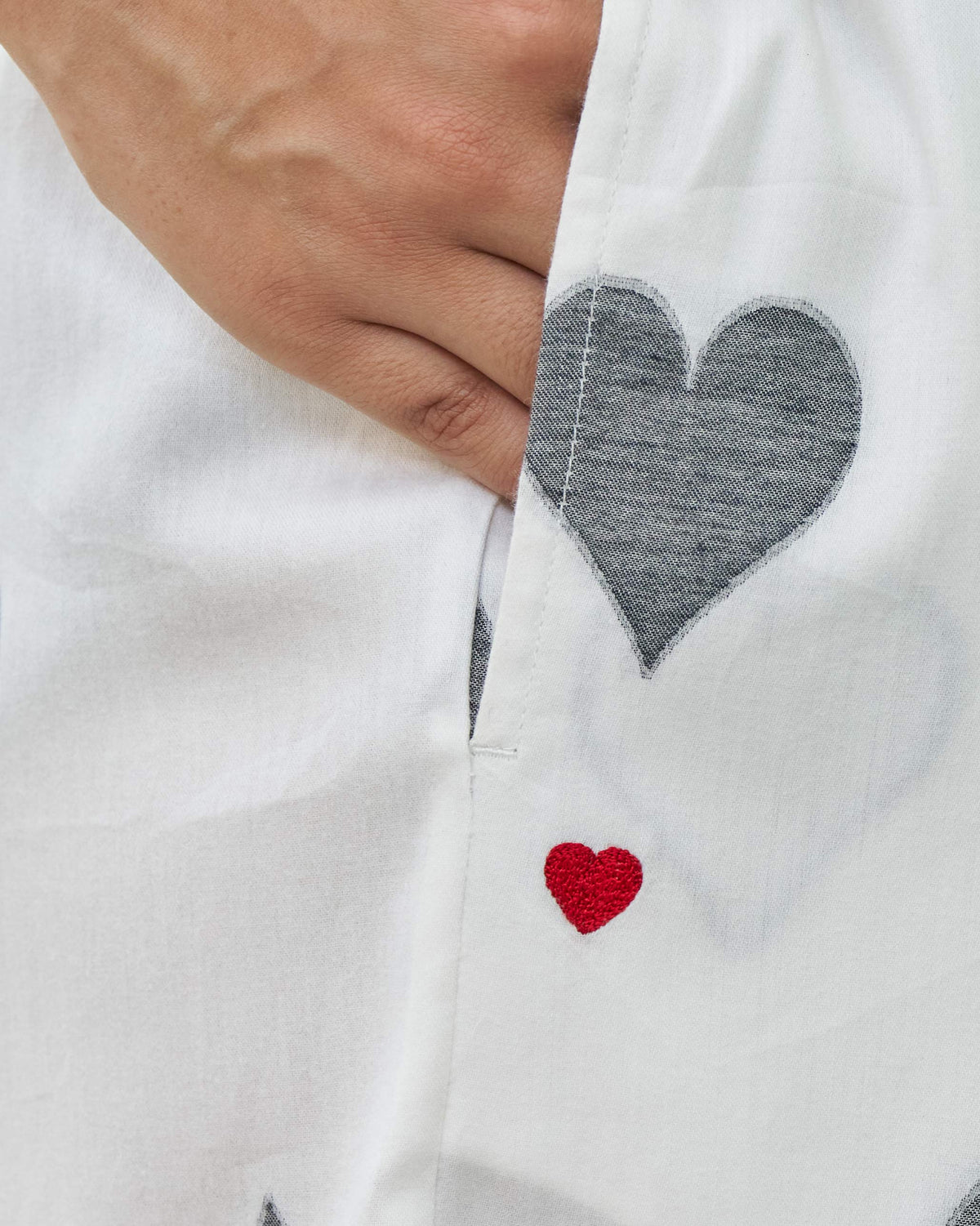 Close-up of Nova pants' side pocket with a small red embroidered heart.