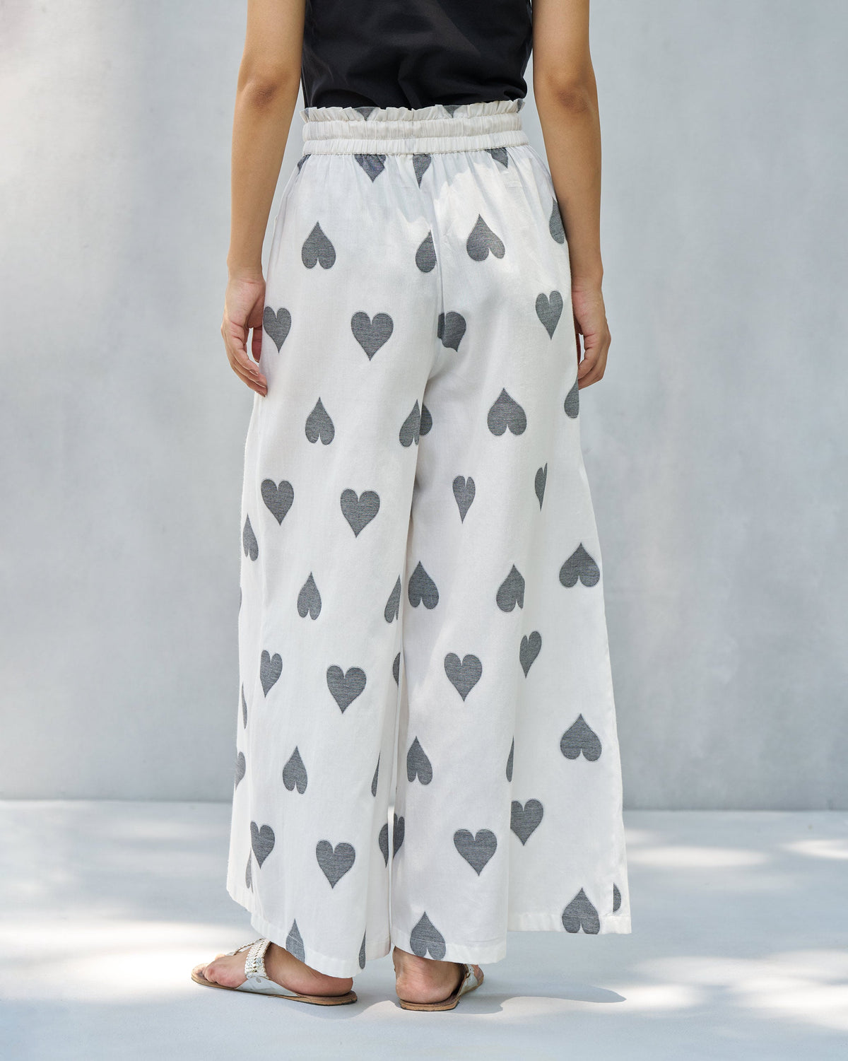Back of Nova pants in ivory with a grey heart print worn by a person.