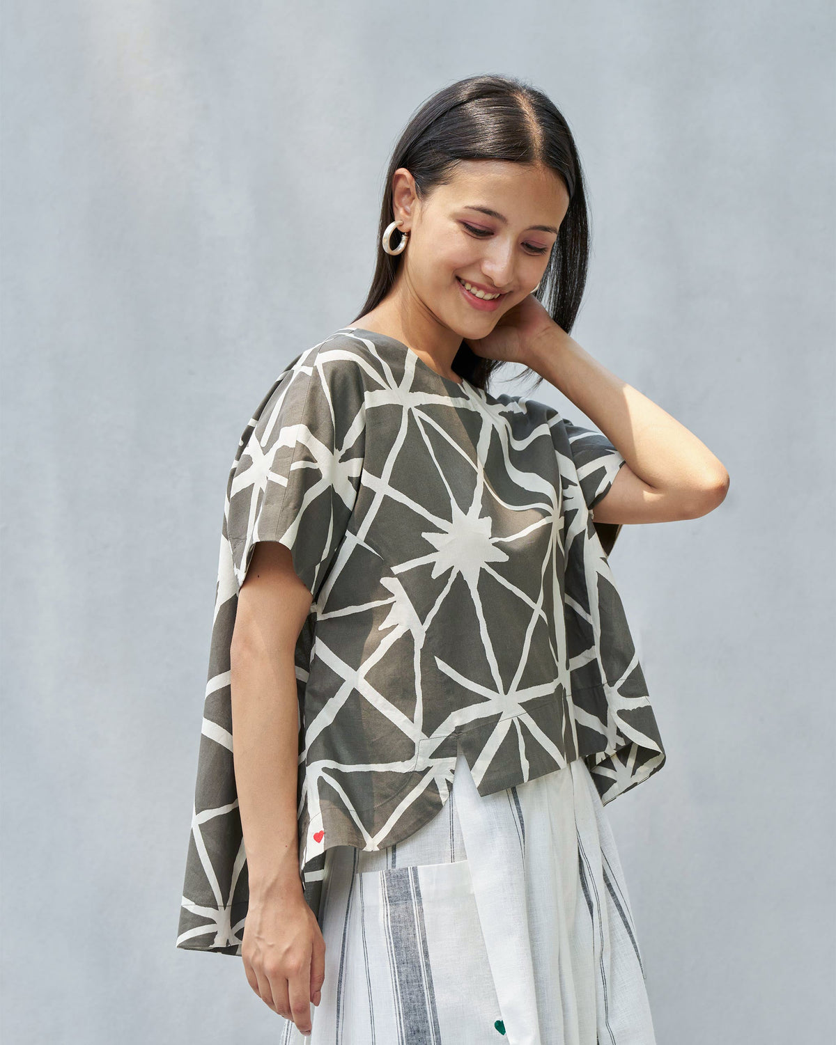 Side view of a Gina top with a wide, boxy cut and short sleeves.