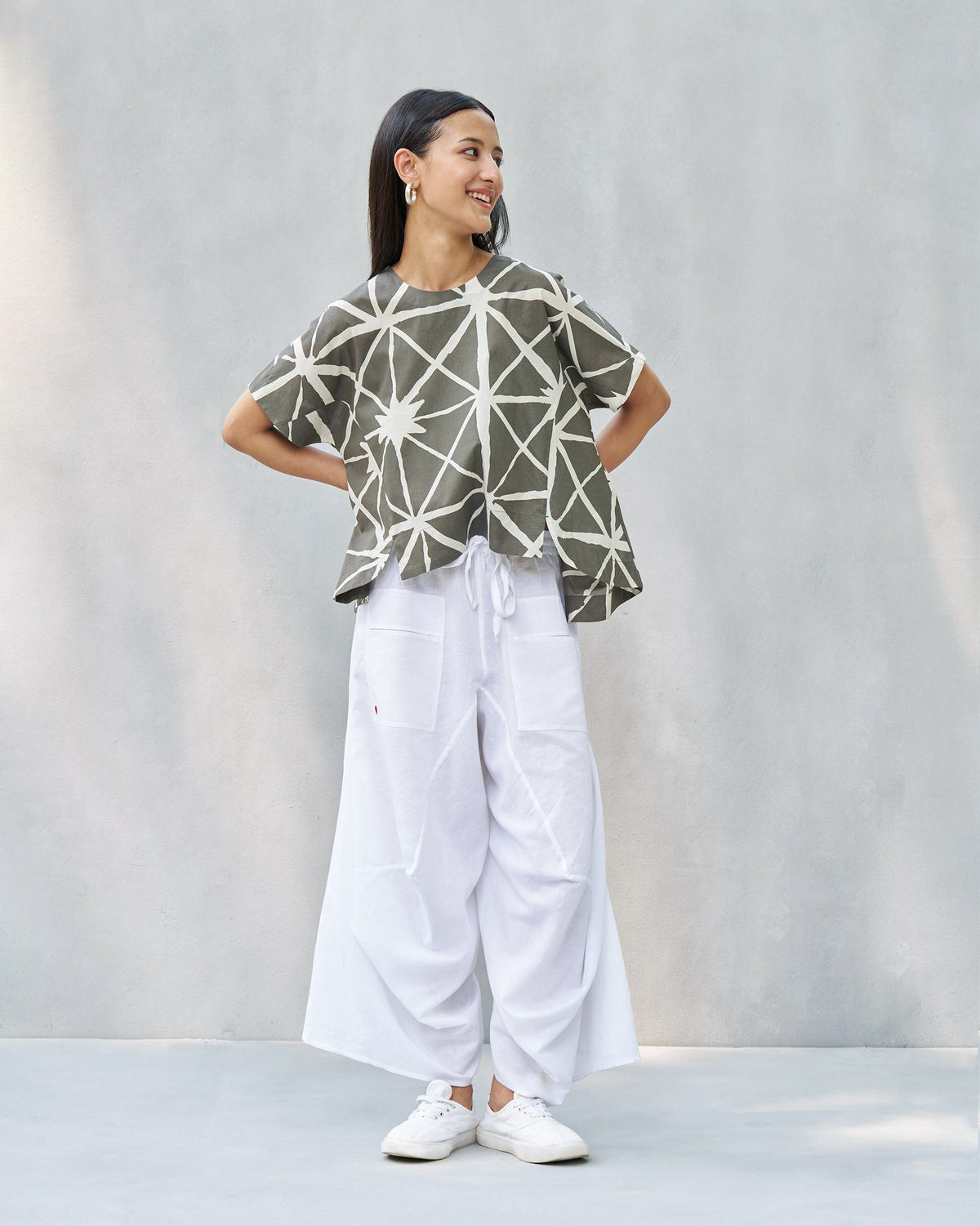 Person wearing a Gina top with a loose, wide-cut silhouette.