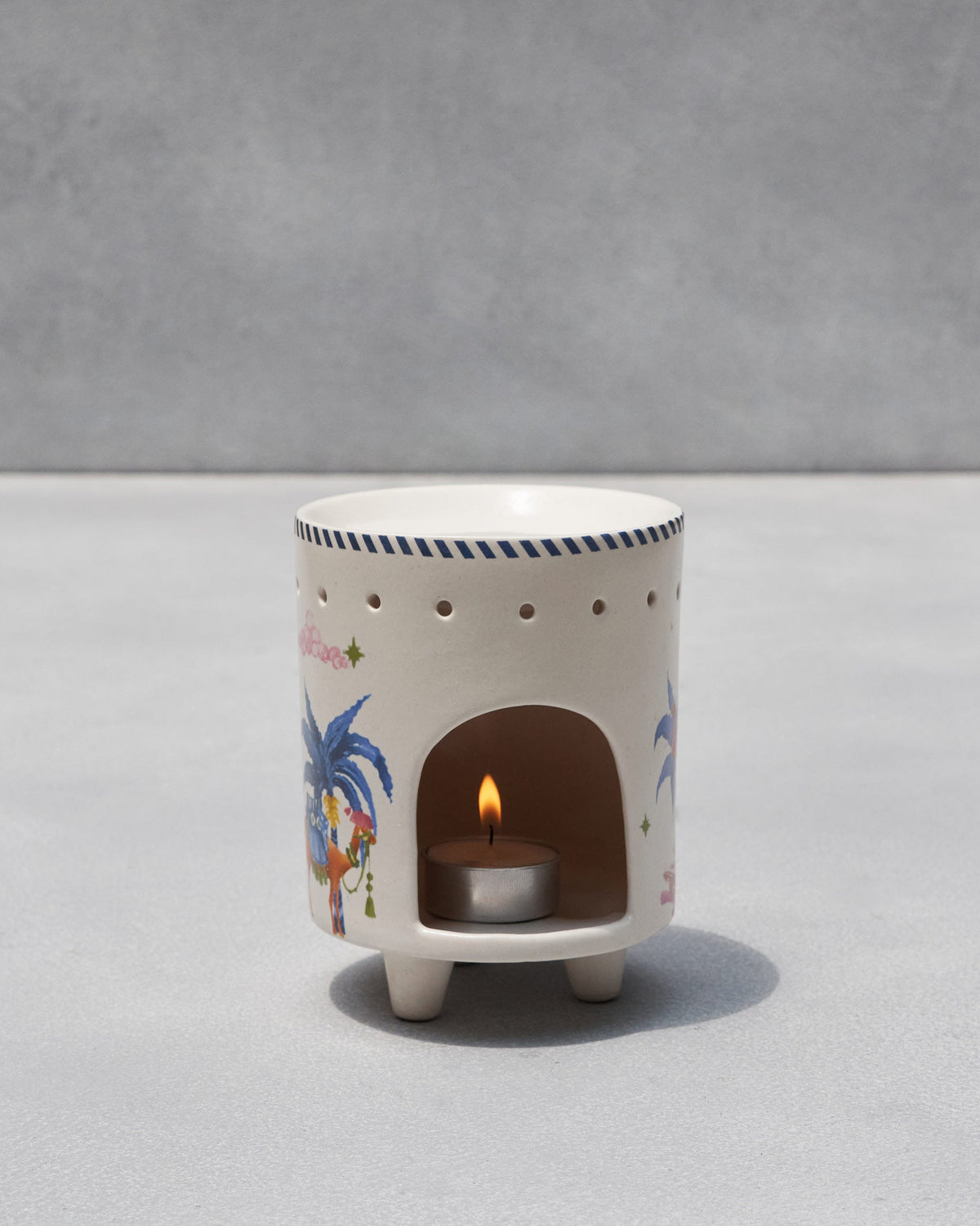 Sahara Diffuser with a lit tea light in its arched opening.