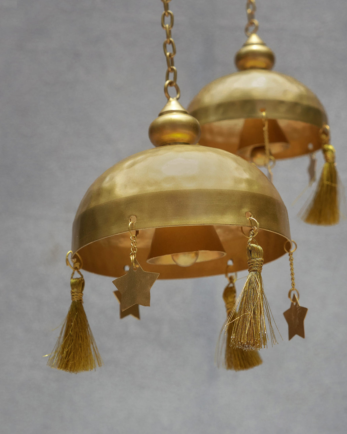 Close-up of the Asfar Windchime showing its brass domes, tassels and star charms.