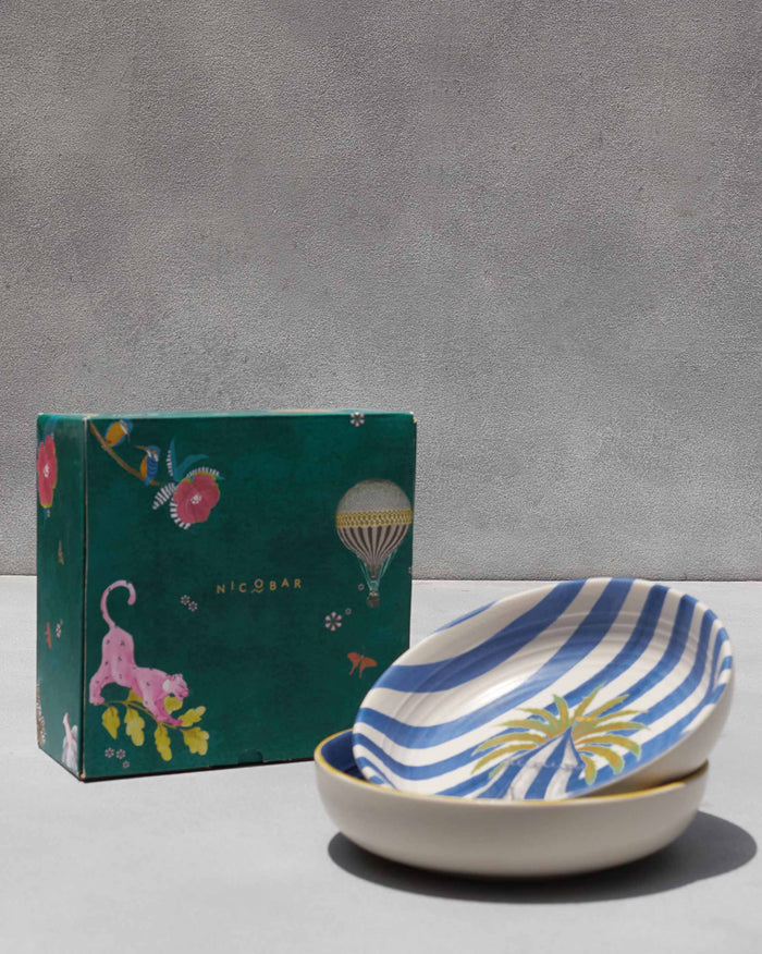 Sahara shallow bowls stacked beside their green Nicobar gift box.