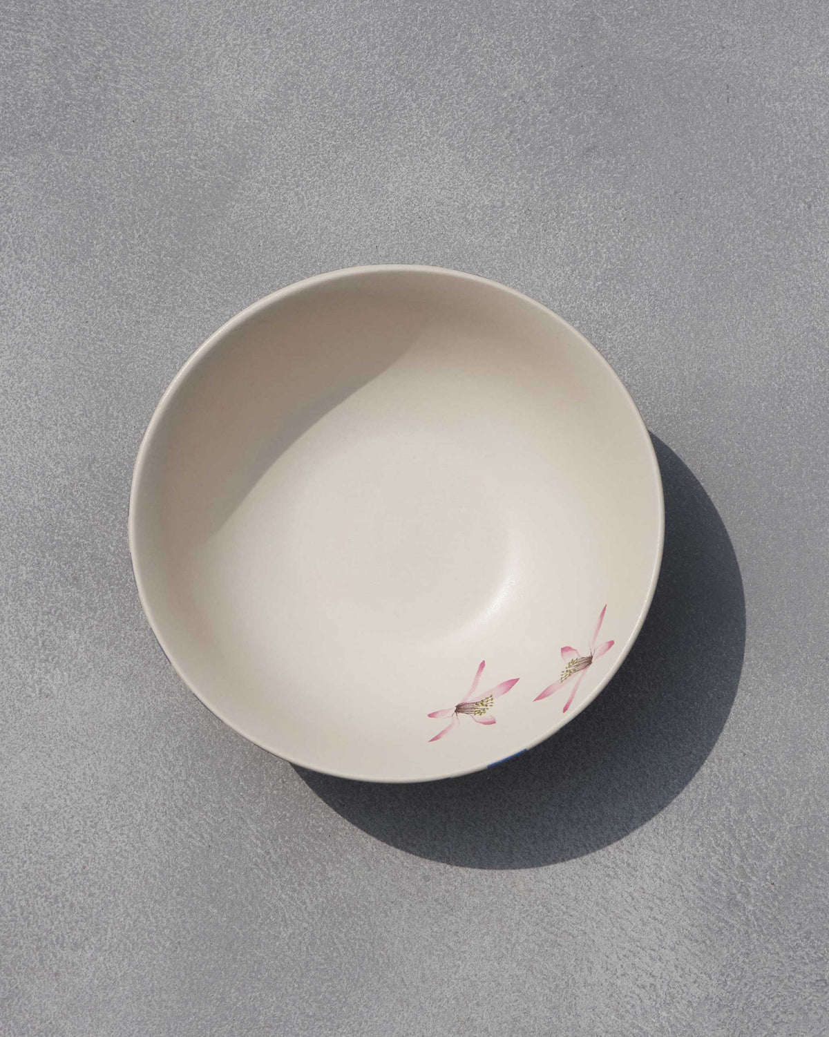 Overhead view of Asfar curry bowl showing pink flowers inside.