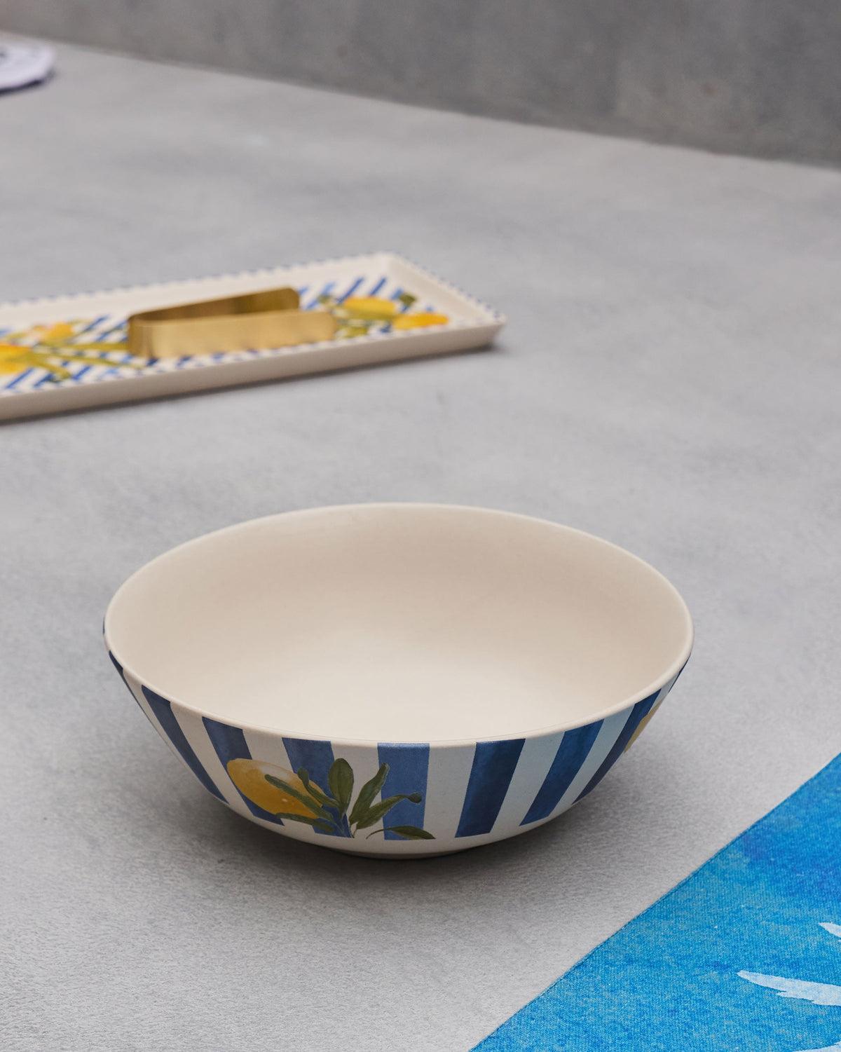 Wider view of Asfar curry bowl with blue stripes and lemon motif.
