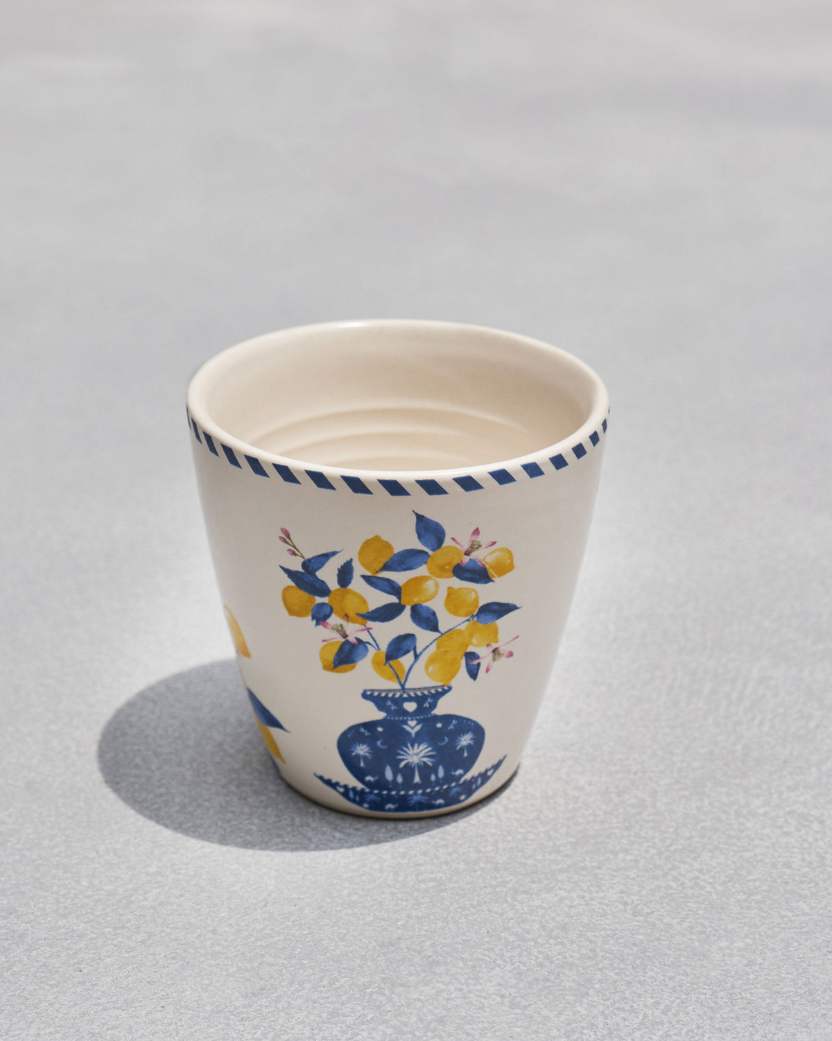 Asfar Conical Mug from an angle, showing the blue vase and lemon motif.