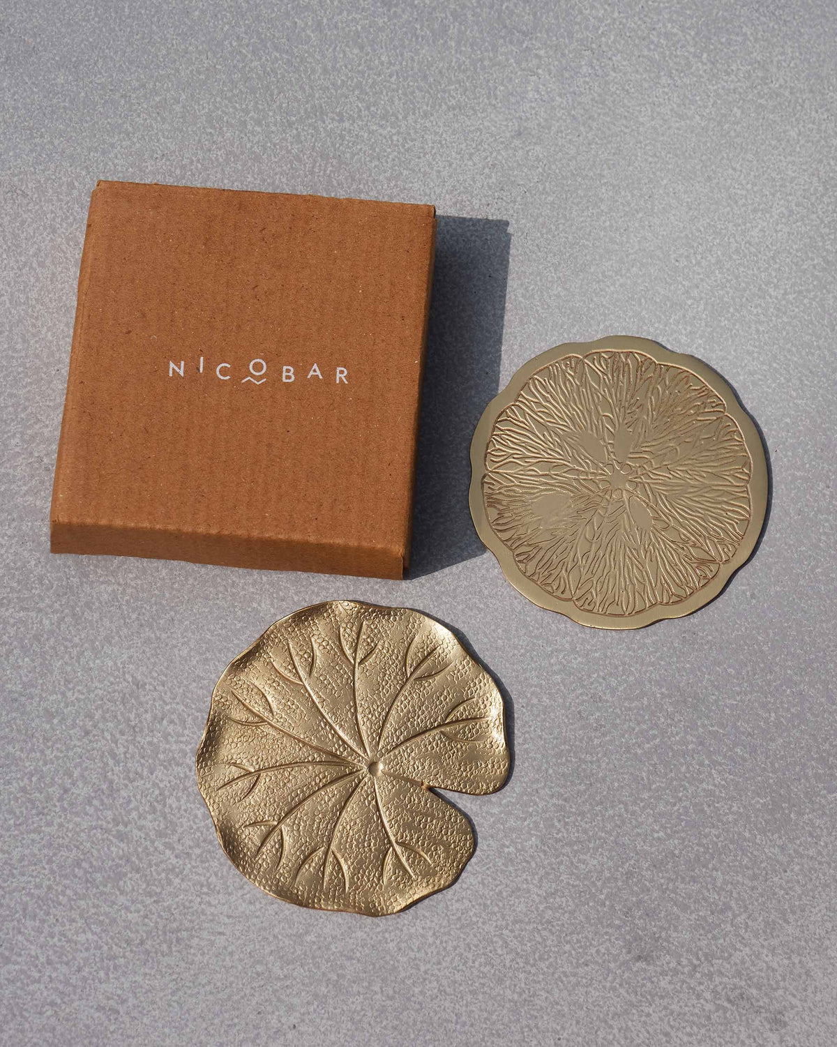 Tangerine Coasters beside a brown Nicobar gift box.