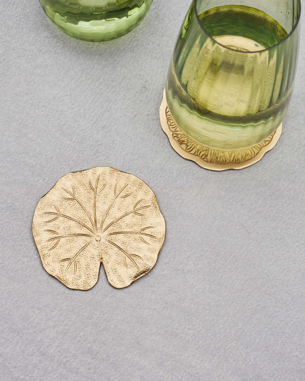 Scalloped Tangerine Coaster under a green glass, beside a leaf-shaped one.