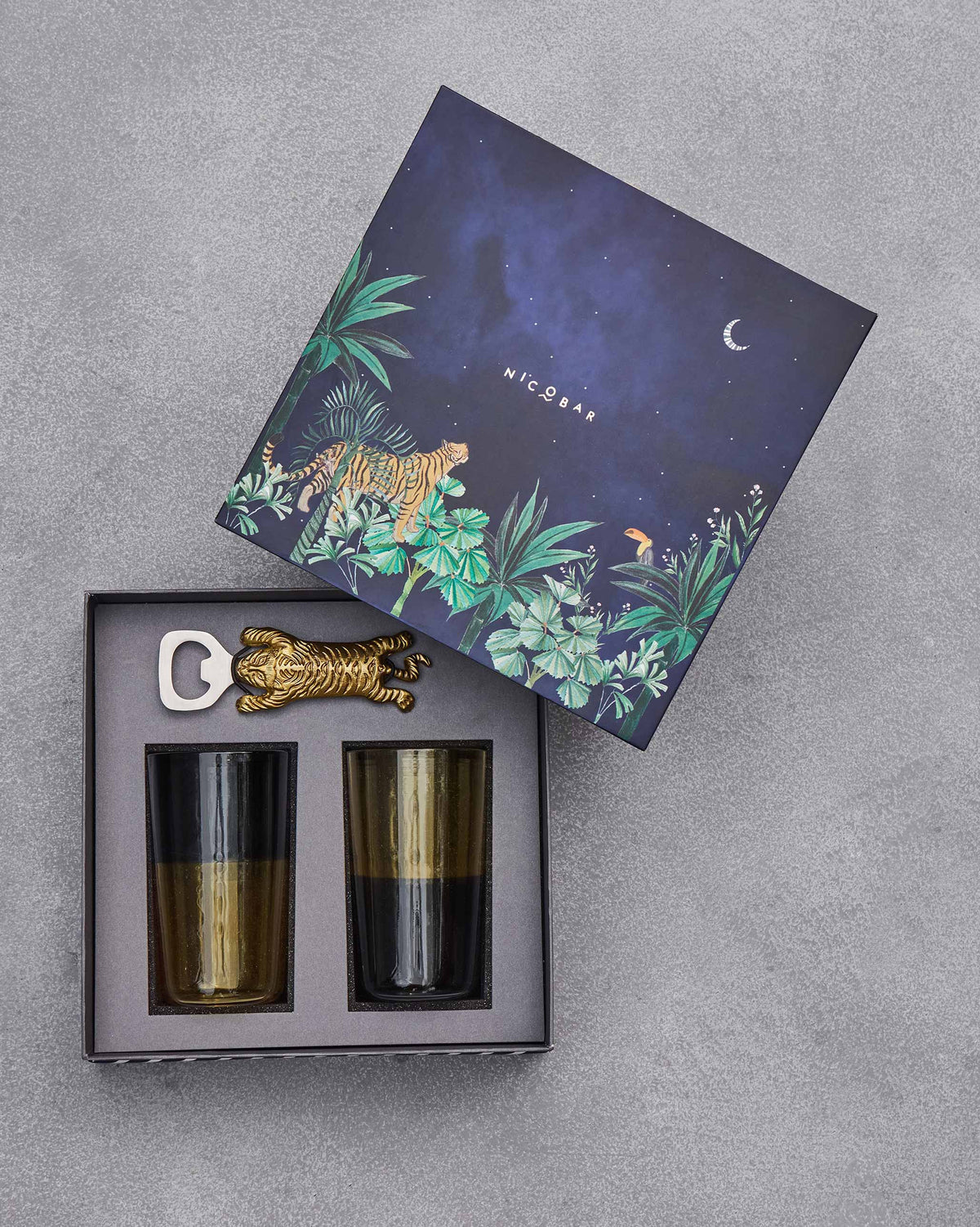 Jungle lid beside an Asfar set of tumblers and a gold tiger bottle opener.