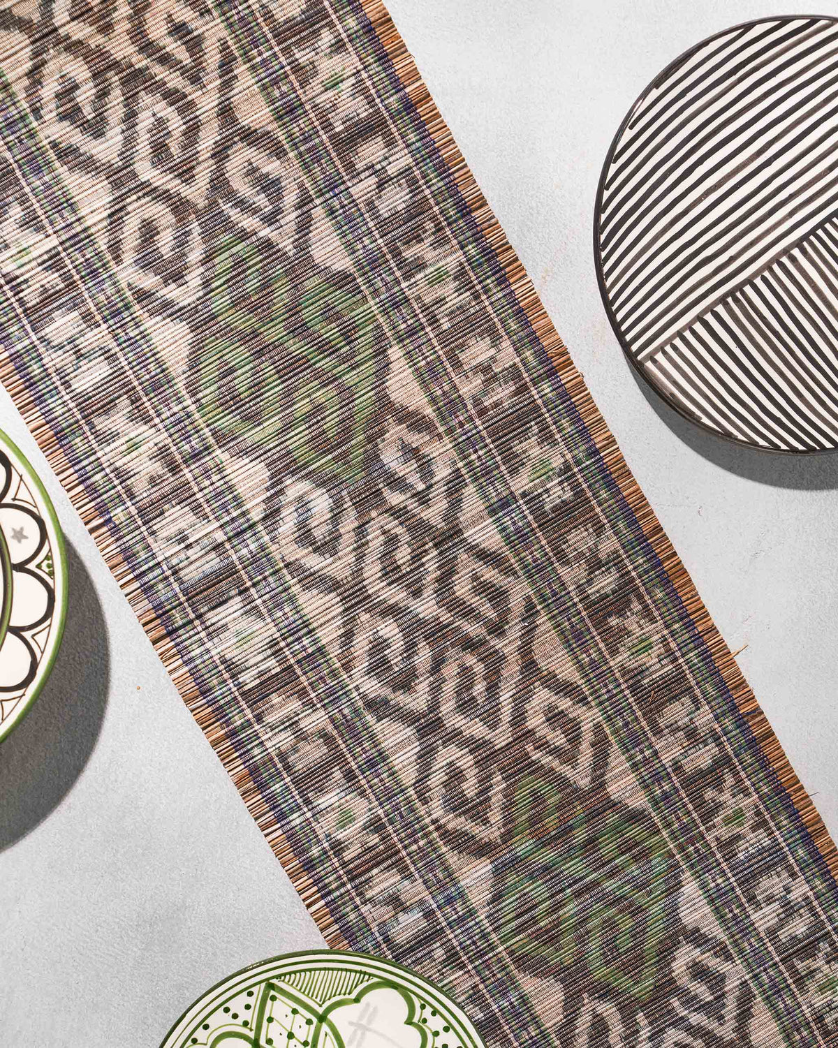 Sitara Ikat Runner laid diagonally on a grey surface.
