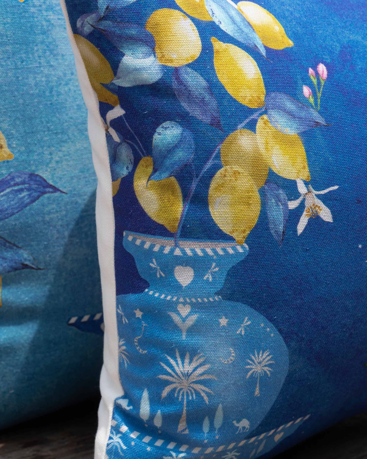 Close-up of Asfar lumbar cushion cover showing a lemon branch in a blue vase.