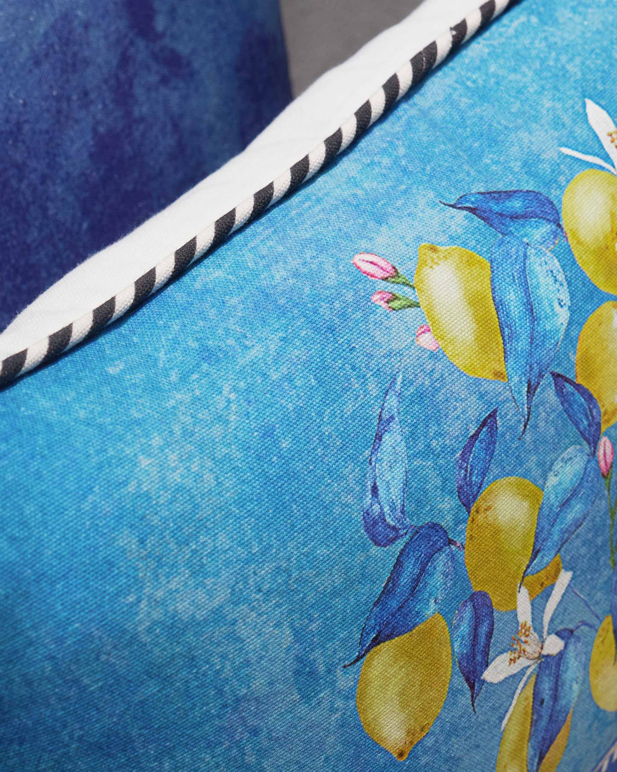 Close-up of the Asfar Cushion Cover showing its lemon and blue leaf print.