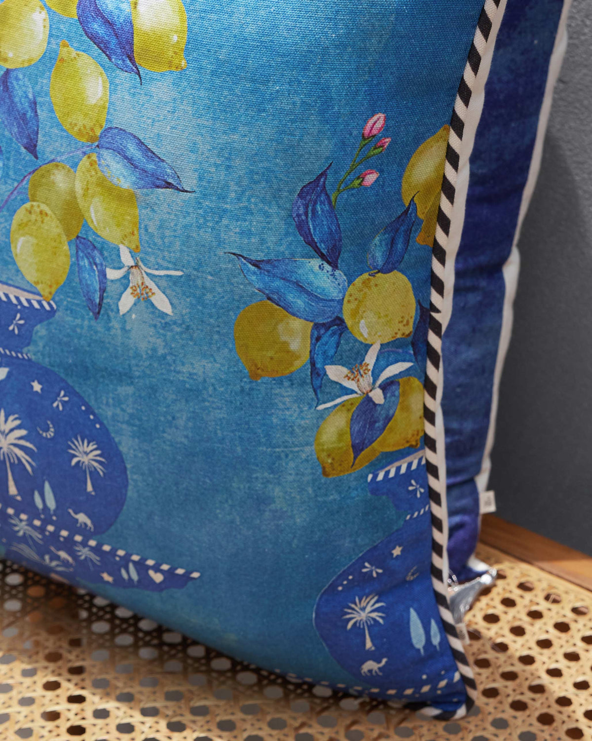 Side view of the Asfar Cushion Cover, showing its lemon print and striped edge.