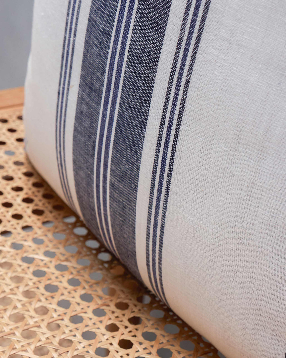 Close-up of the Sahara French Stripe Cushion Cover showing its navy stripes and frayed edge.