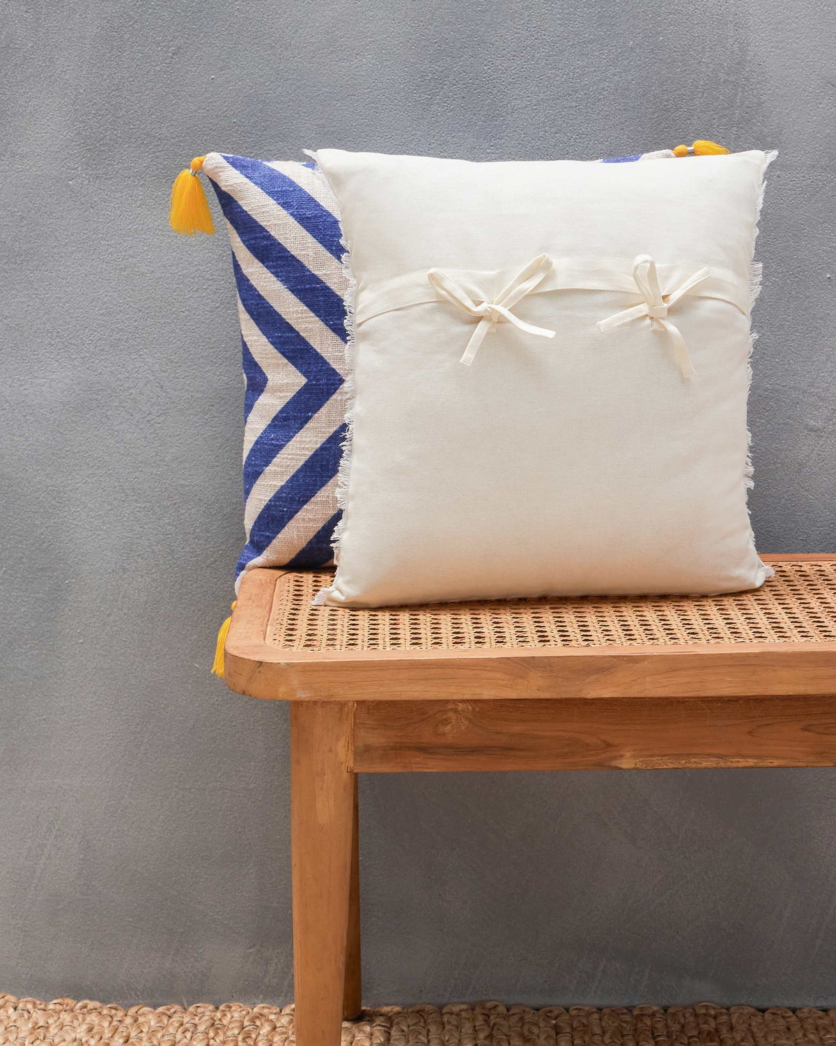Back of the Sahara French Stripe Cushion Cover in plain cream with bow ties.