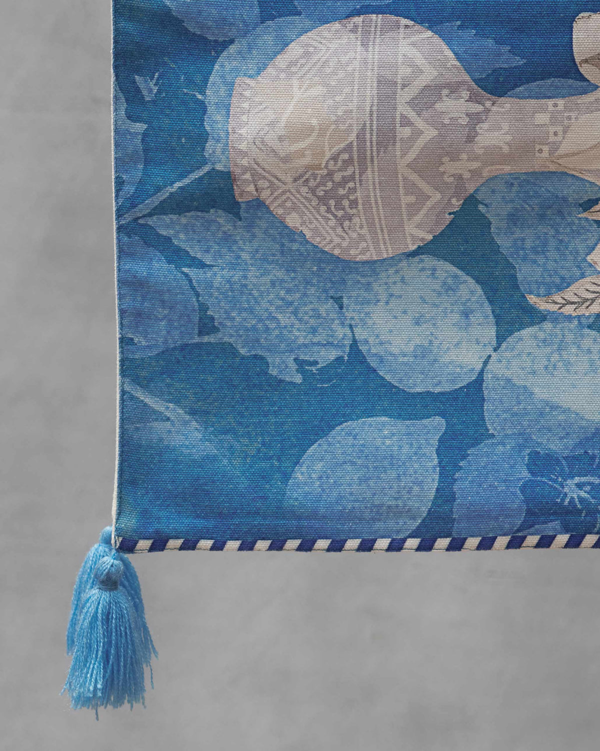 Close-up of Azraq table runner showing a patterned vessel motif and blue tassel.