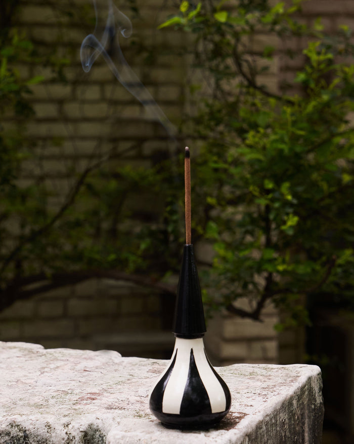 Asfar Incense Holder with 12 Incense Sticks, black and cream, with a stick burning.