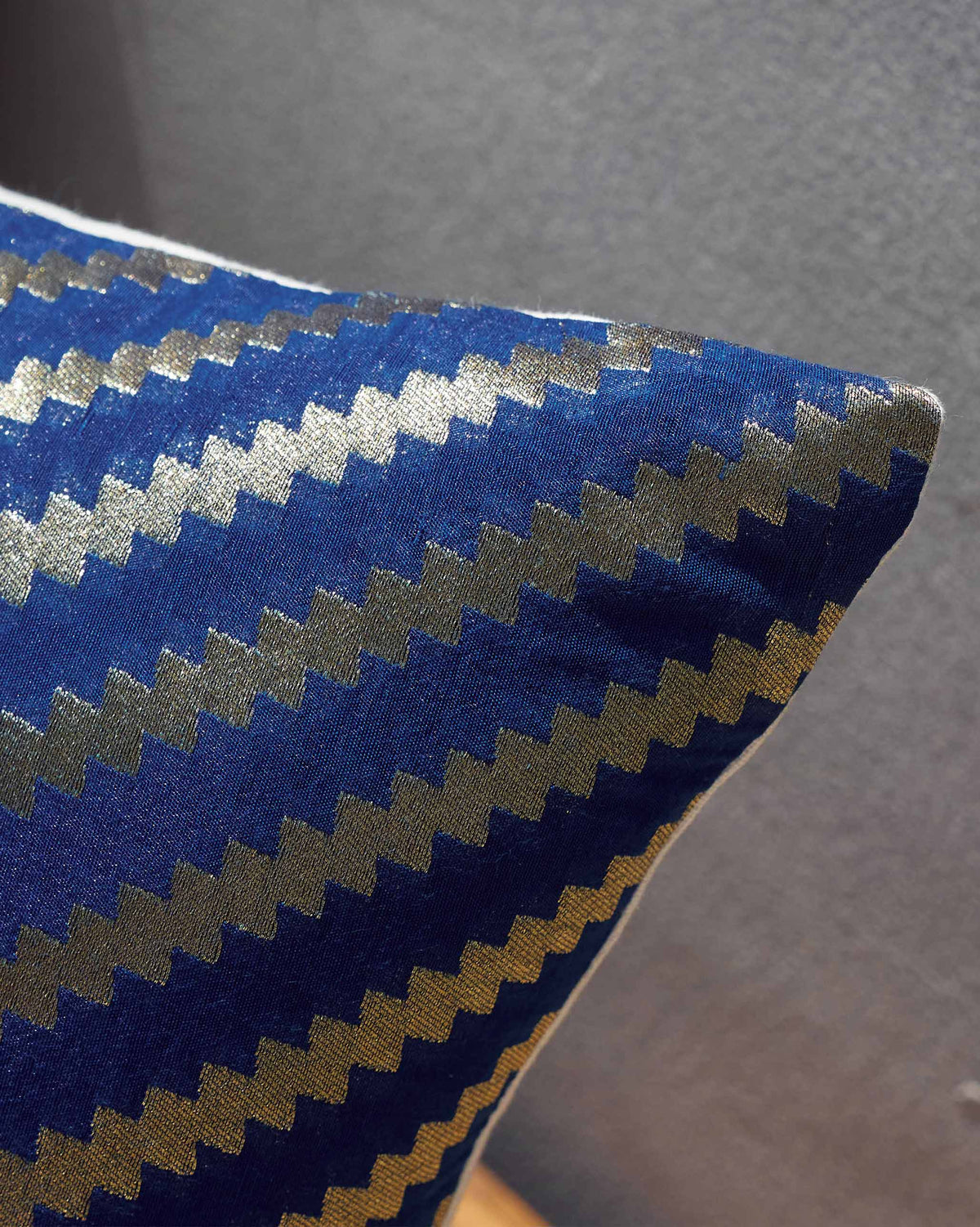 Close-up of the Whimsical Chanderi Lumbar showing its blue and gold zigzag stripes.