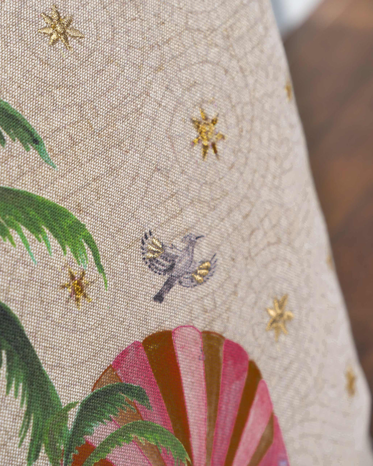 Close-up of Chambray Arch Cushion showing a grey bird and gold stars.