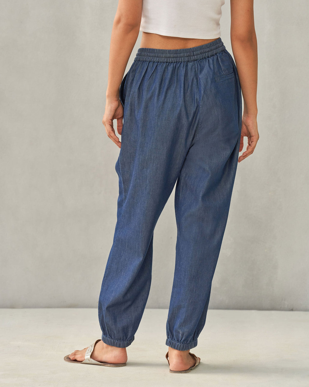 Back of denim Jogger Pants worn by a person.