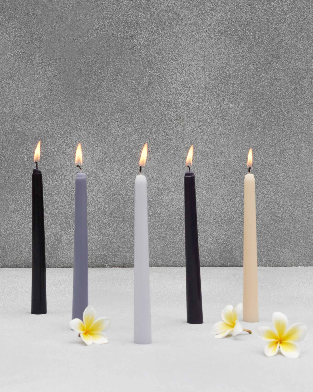 Twilight Tapered Candles - Set of 10 lit in a row in black, grey and cream.