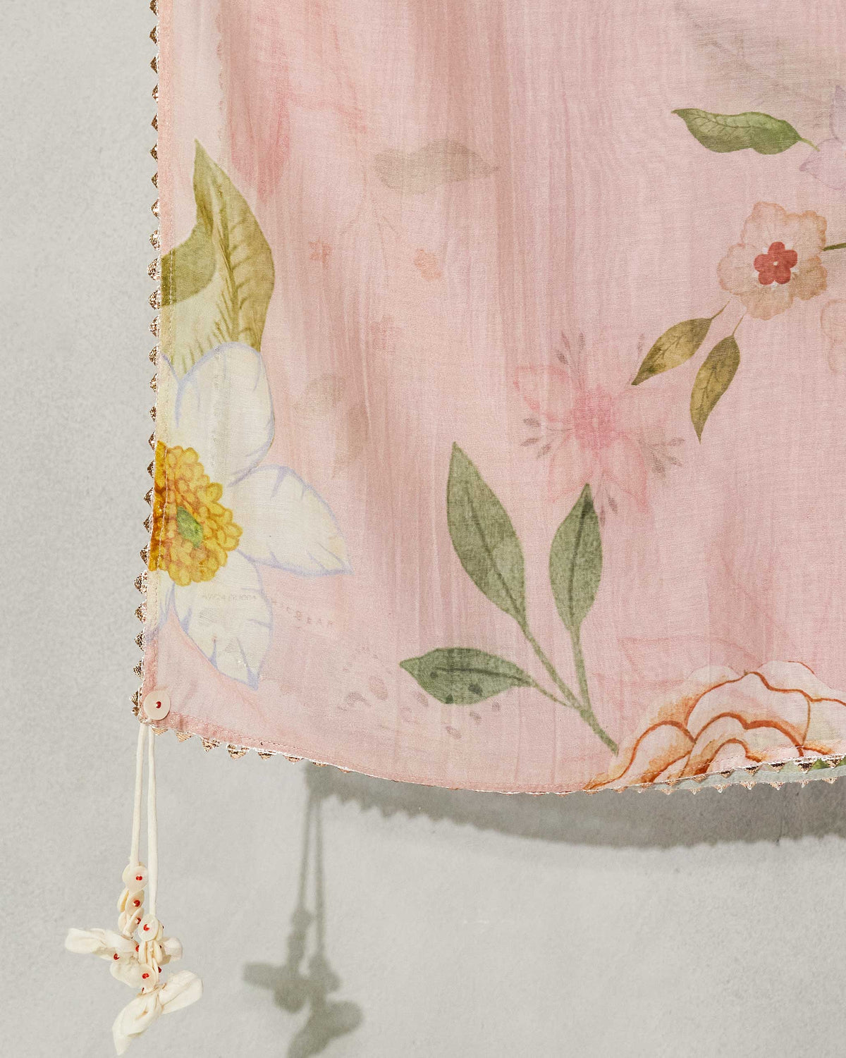 Close-up of a Paradise Dupatta corner showing white and yellow flowers and green leaves.