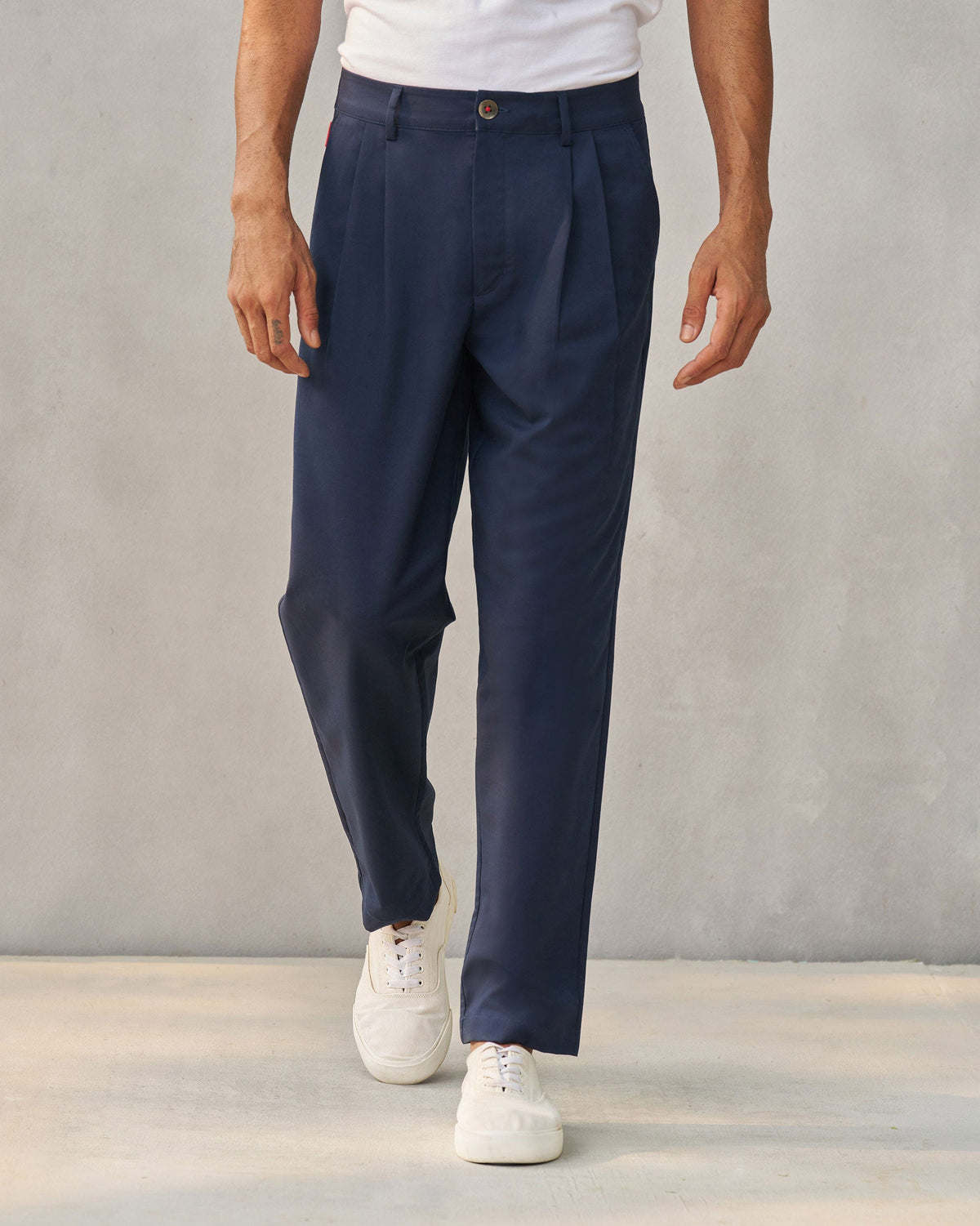 Person wearing navy Forty Trousers with front pleats.