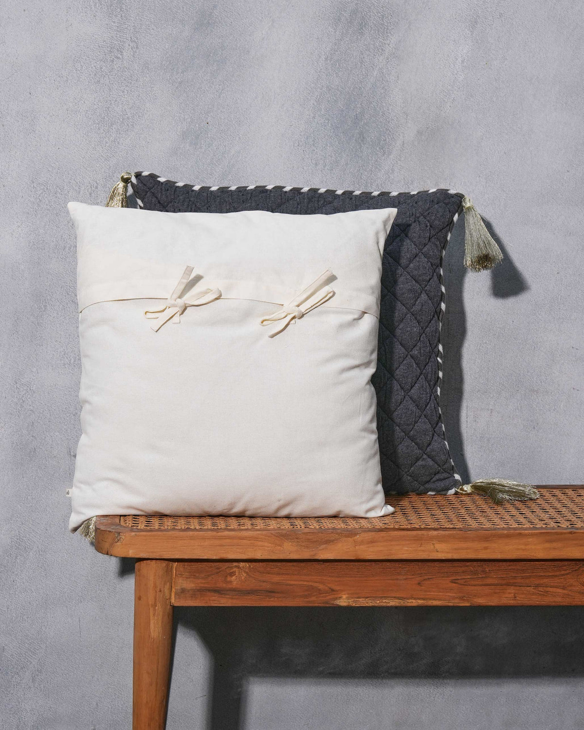 Plain cream side of the Shimmer Cushion Cover with two bow ties.