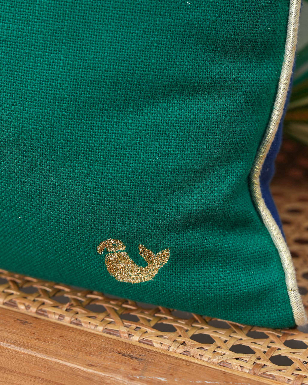 Desert Lagoon Cushion Cover in green with a small gold bird motif in one corner.