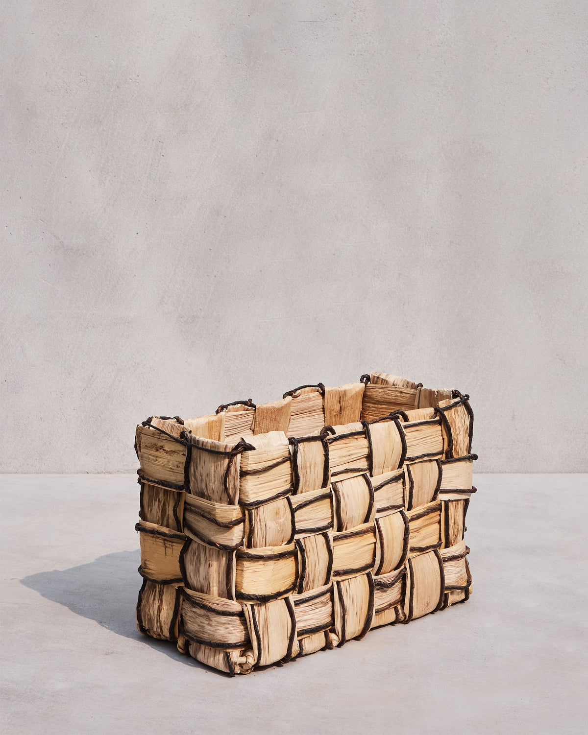 Front of a small Mosaic basket with a beige and dark brown mosaic weave.
