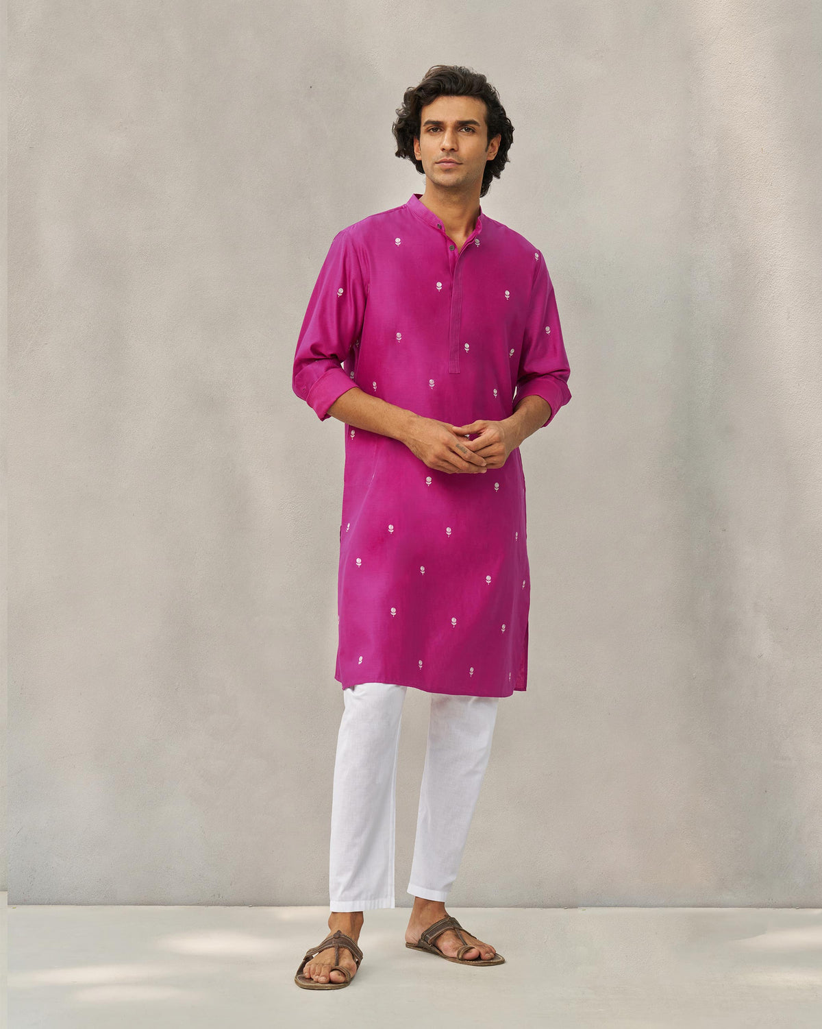 Person wearing a magenta neckband kurta with small embroidered motifs.