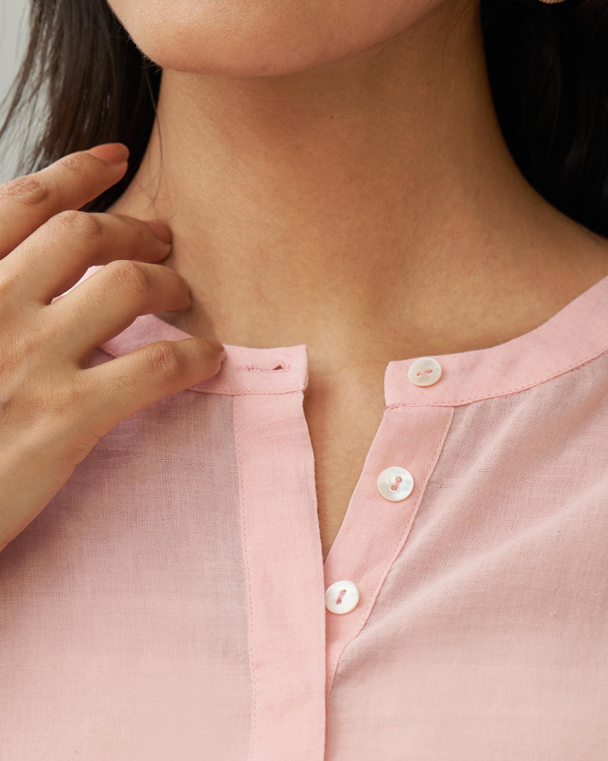 Close-up of the pink Lazy Sunday tunic band collar and white buttons.