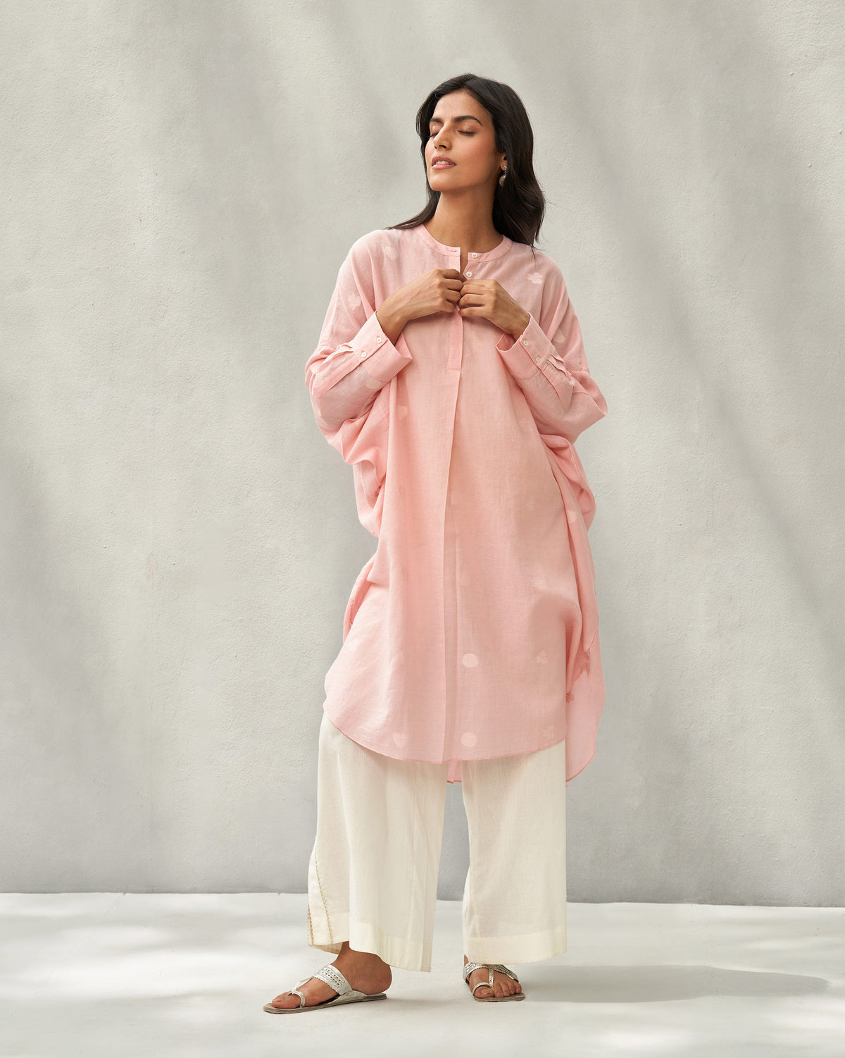 Person standing with hands at the placket in a pink Lazy Sunday tunic.