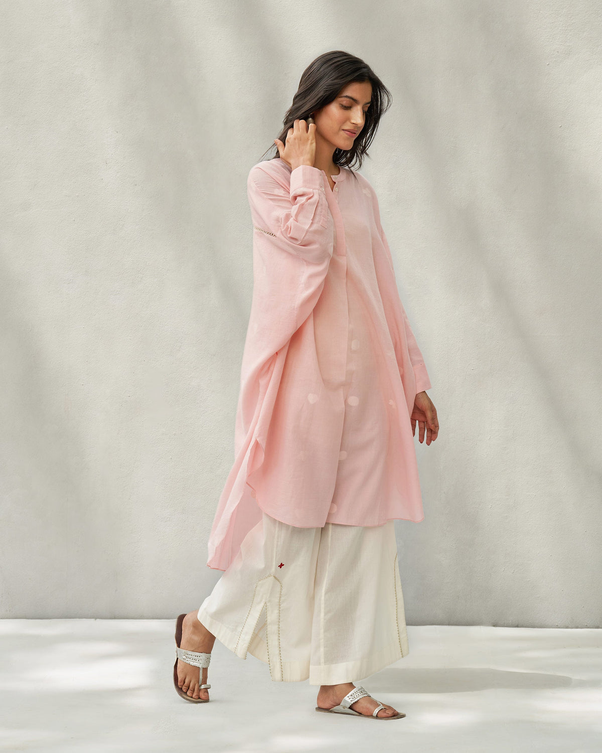 Side view of a pink Lazy Sunday tunic with a curved hem, worn by a person.