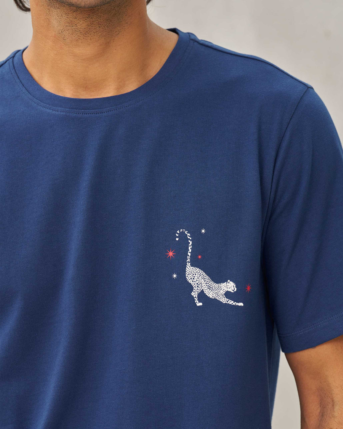 Close-up of a navy Party Cheetah T-shirt chest showing a stretching cheetah motif.
