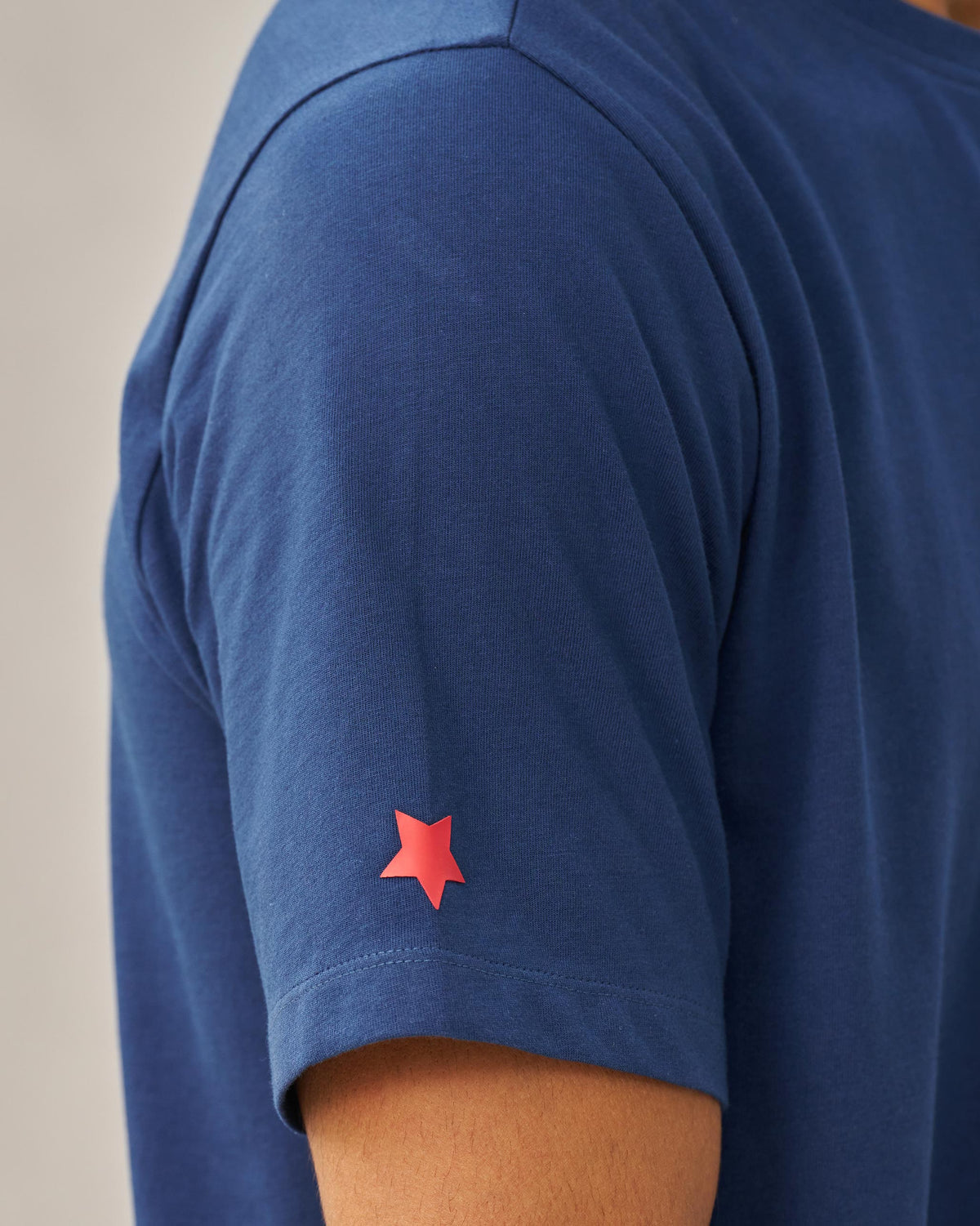 Close-up of a red star on the sleeve of a navy Party Cheetah T-shirt.